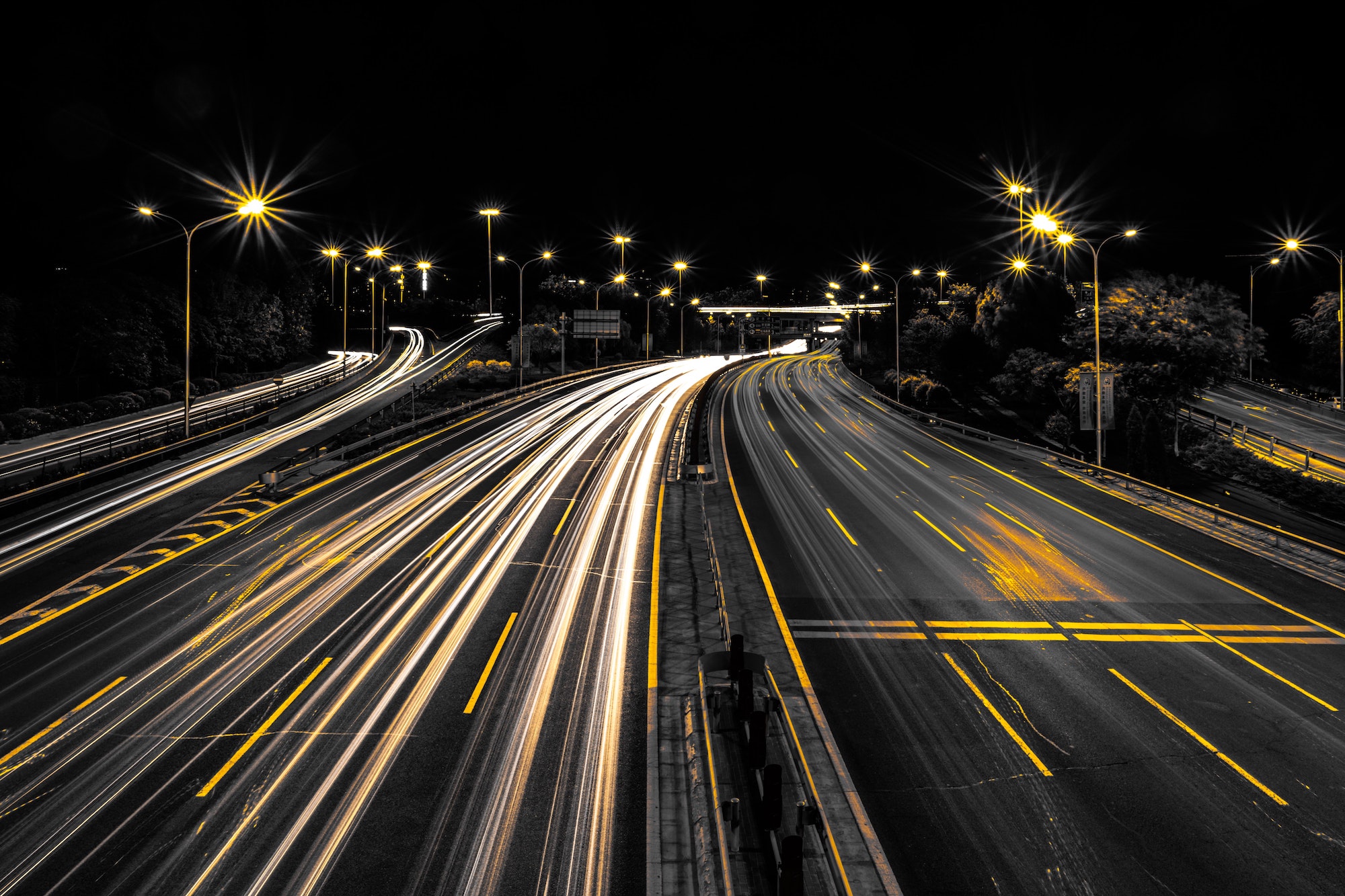 Long-exposure showing streaks of cars on highway at night, demonstrating speed provided by hyperautomation and automating ap