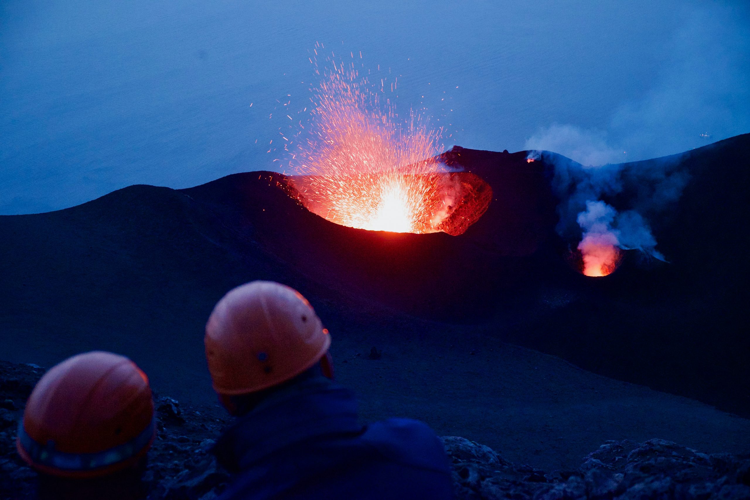 workers in hard hats looking at erupting volcano, symbolizing the increasing volatility in the fiscal landscape